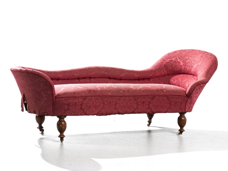 KANAPÉ, med hjultrissor och svarvade ben i valnöt, fast stoppad klädsel, ca 1875. Slitet tyg med hål, i övrigt bruksskick.